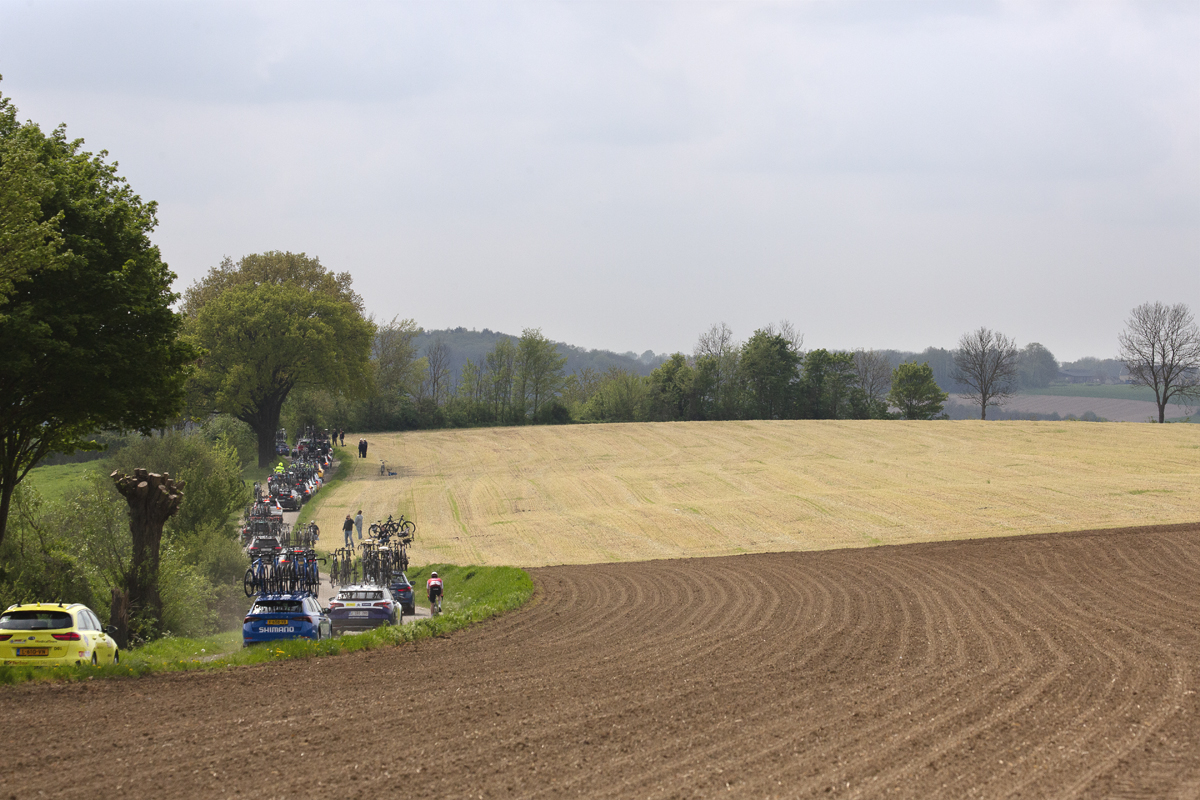 Amstel Gold Race 2024 - Team cars follow the race with one rider seen moving through the convoy on Heugdenweg