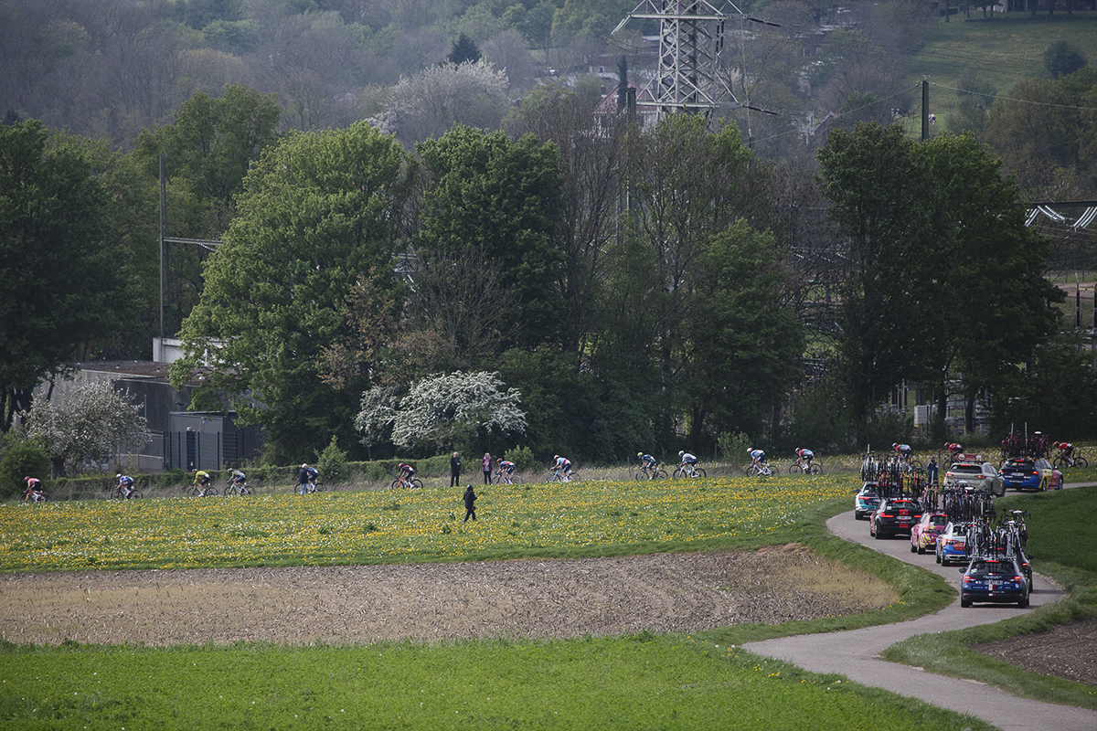 Amstel Gold Race 2024 - The race seen from a distance on Scheumerweg as team cars snake their way in pursuit