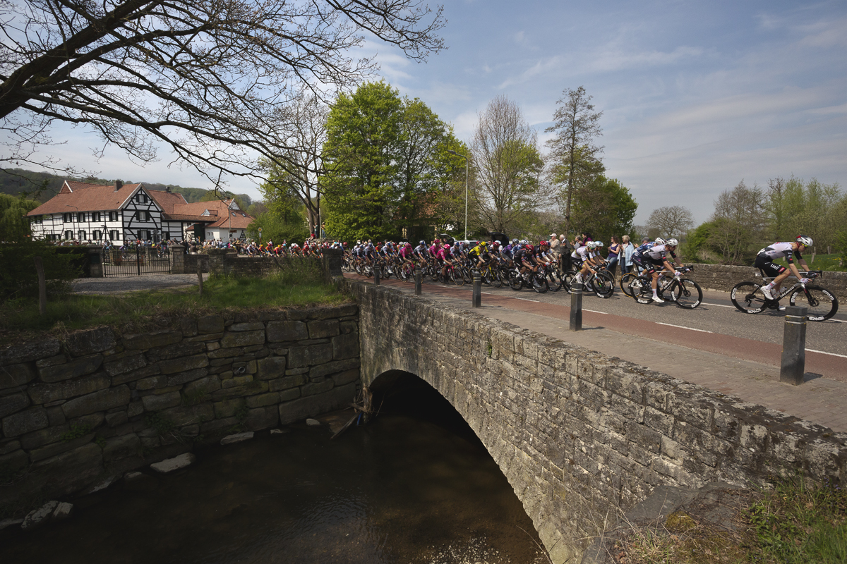 Amstel Gold Race 2025 - Riders cross a stone bridge on their approach to Mechelen