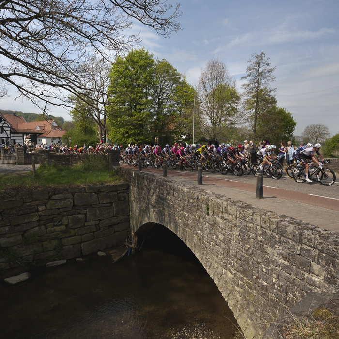 Amstel Gold Race 2025 - Riders cross a stone bridge on their approach to Mechelen