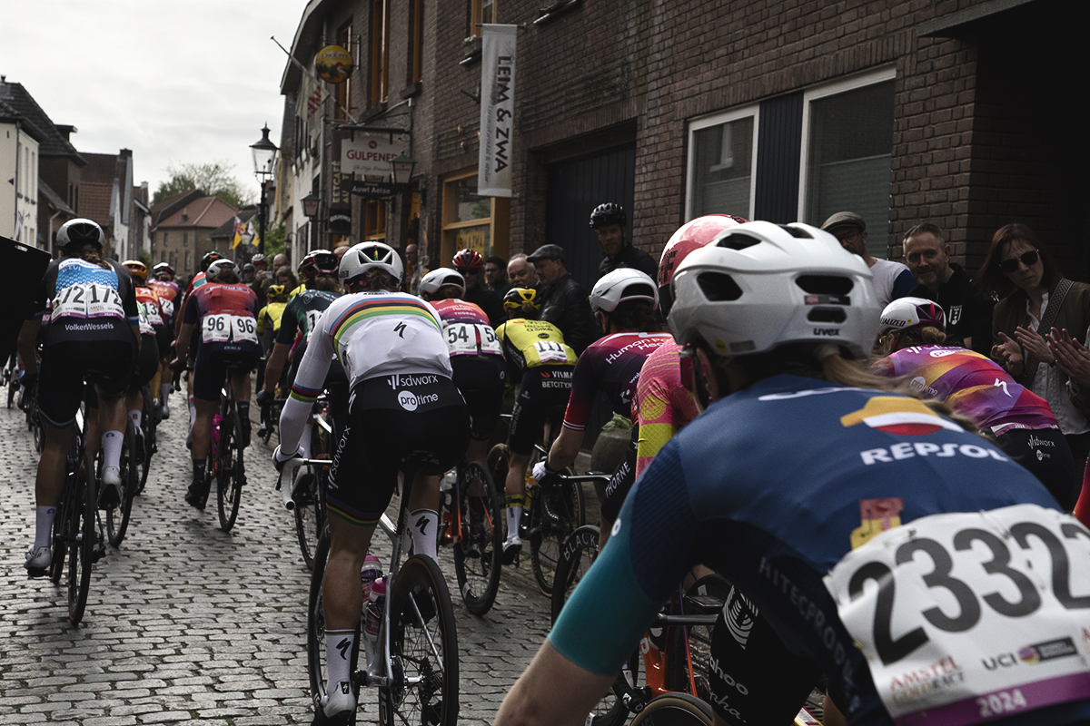 Amstel Gold Race Ladies Edition 2024 - Riders watched on by fans race up the cobbled street of Elsloo