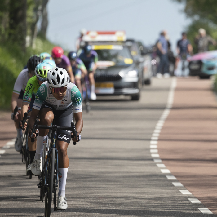 Amstel Gold Race Ladies Edition 2025 - Andrea Alzate leads a group closely followed by one of the race cars