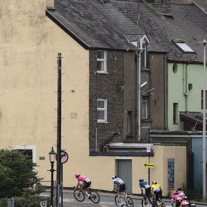 British National Road Championships 2025 - Road Race - Men - riders race past a row of terraced houses in Aberystwyth