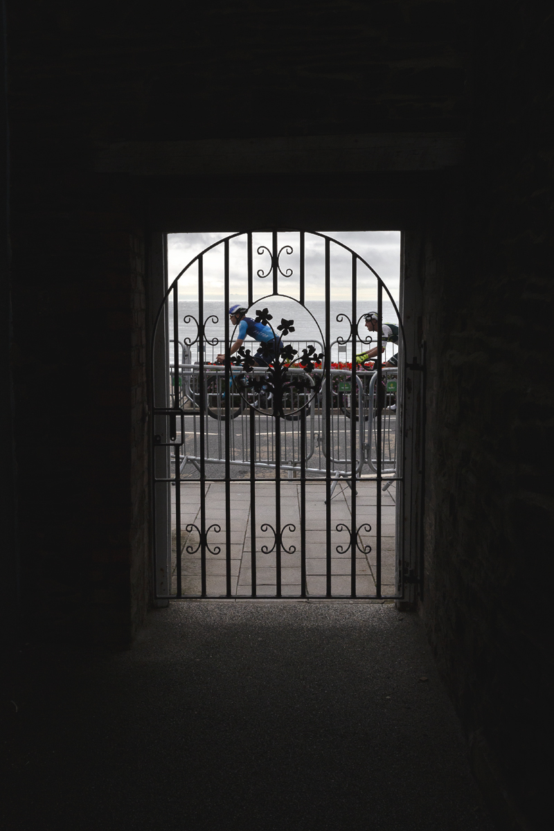British National Road Championships 2025 - Road Race - Men - Euan Woodliffe & Oliver Wood seen through an ornate gate as they race down the sea front