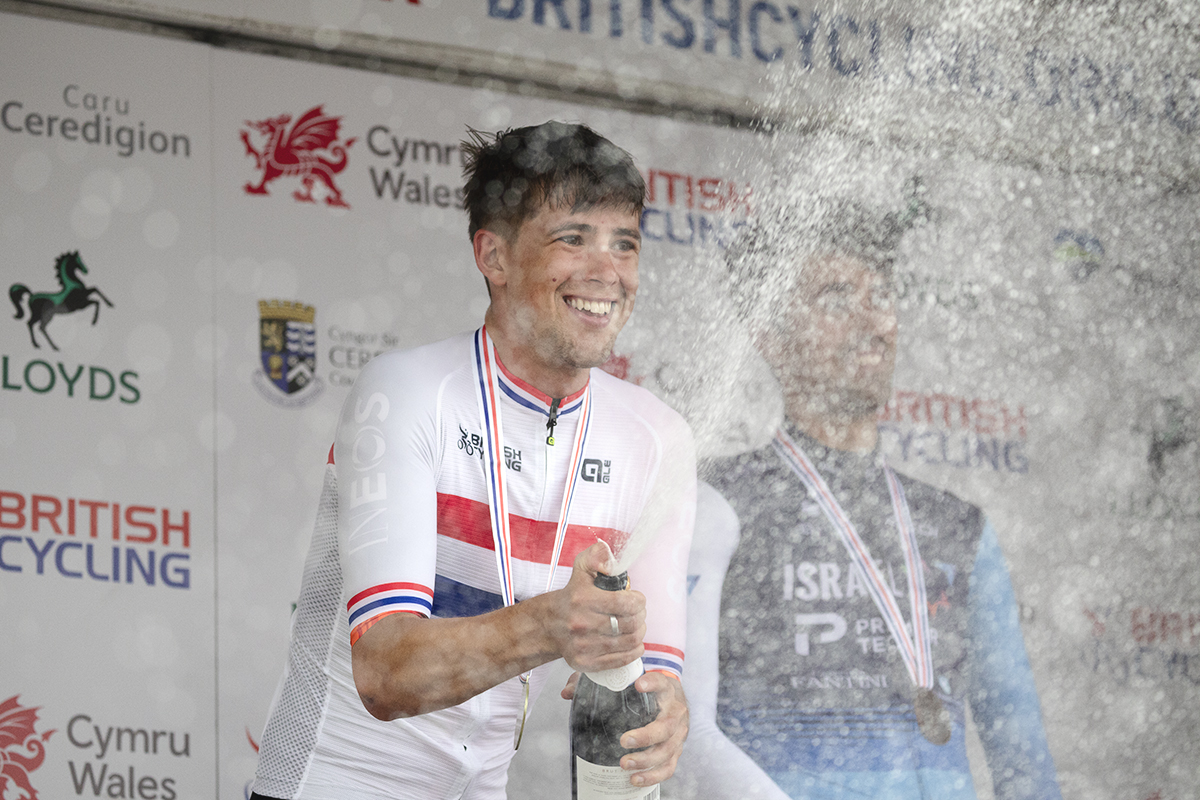 British National Road Championships 2025 - Road Race - Men - Sam Watson of Ineos Grenadiers wears his National Champions jersey and sprays sparkling wine in celebration on the podium