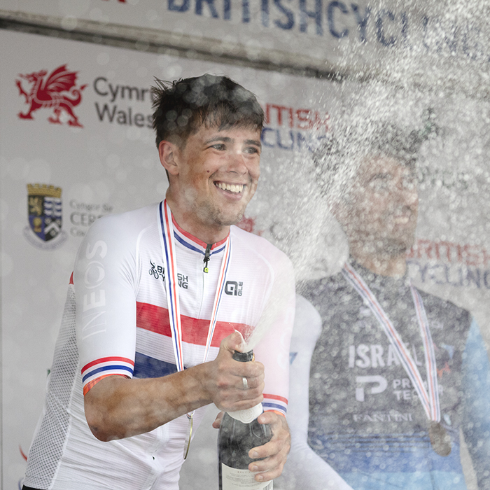 British National Road Championships 2025 - Road Race - Men - Sam Watson of Ineos Grenadiers wears his National Champions jersey and sprays sparkling wine in celebration on the podium