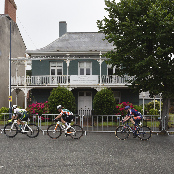 British National Road Championships 2025 - Road Race - Women - Aberystwyth - a group of riders pass a colonial looking house