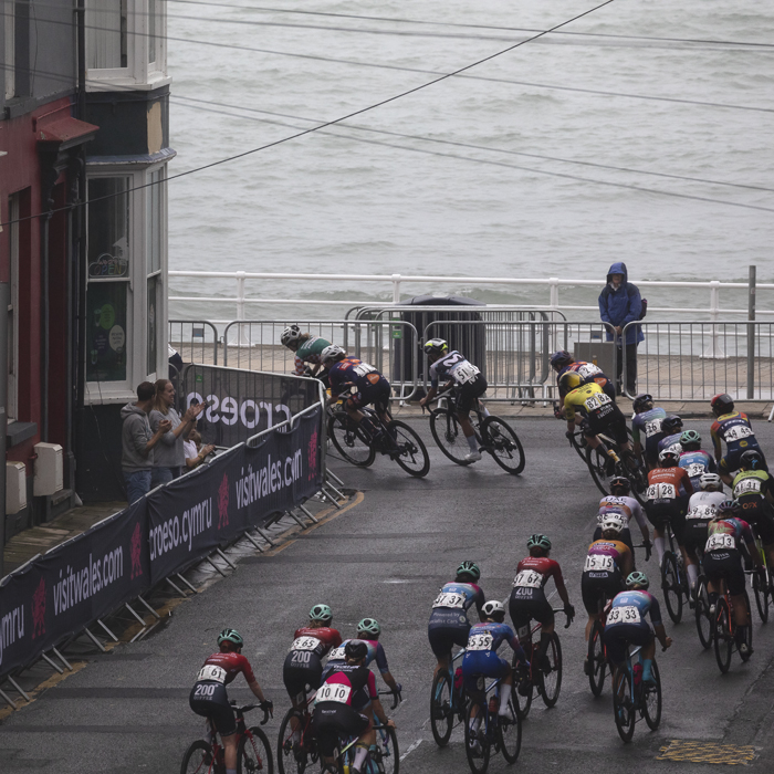 British National Road Championships 2025 - Road Race - Women - Aberystwyth - riders take a corner onto the seafront with guesthouses to the side