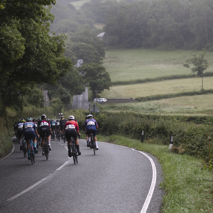 British National Road Championships 2025 - Road Race - Women - Rhydyfelin - a rear view of riders with the road stretching out in front and a view over the fields to one side