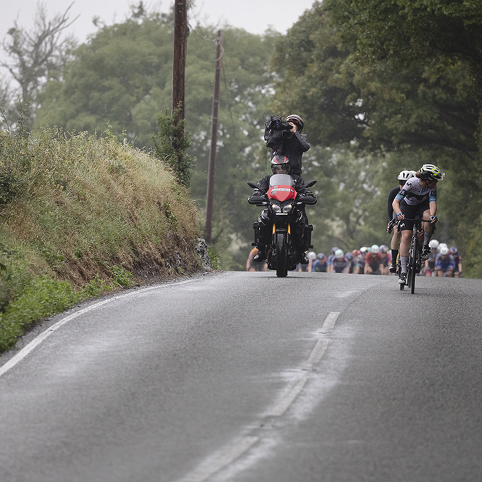 British National Road Championships 2025 - Road Race - Women - Rhydyfelin a Movistar rider looks behind at the peloton just cresting a rise behind her