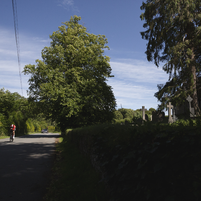British National Road Championships 2025 - Time Trial - Elite Men - Connor Swift passes by a small cemetery during the event