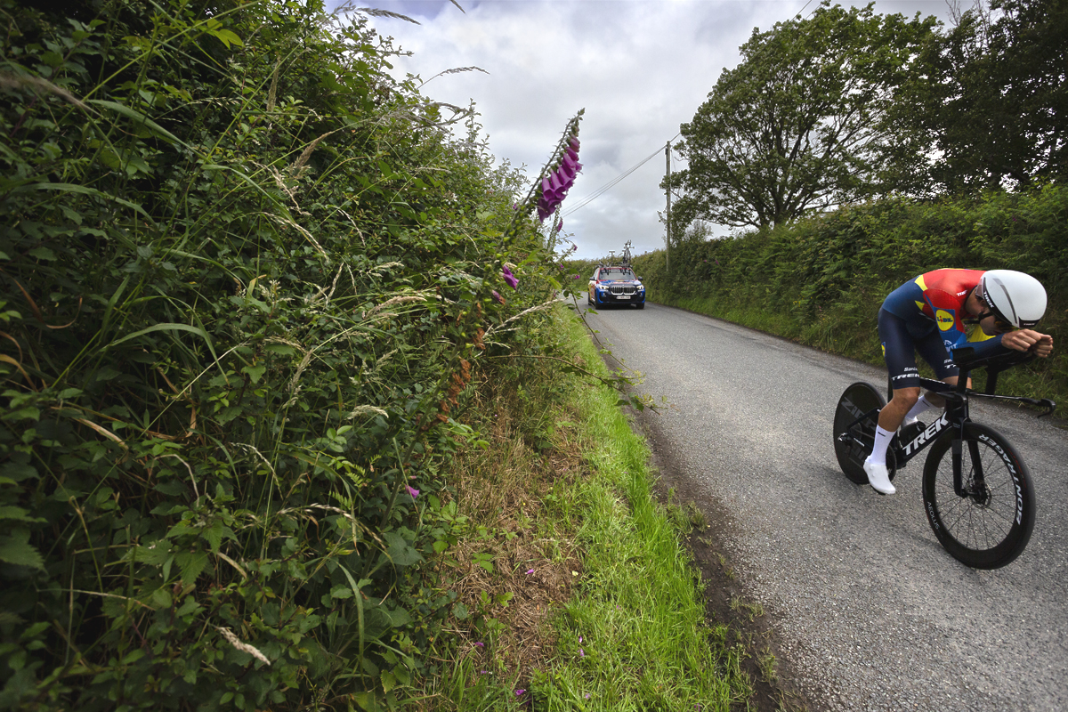 British National Road Championships 2025 - Time Trial - U23 Men - Seb Grindley of Lidl - Trek Future Racing passes foxgloves in the hedgerow