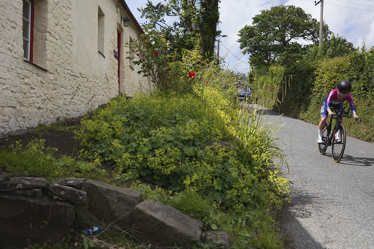 British National Road Championships 2025 - Time Trial - Elite Women - Kate Richardson of Handsling Alba Development Road Team passes by a traditional Welsh cottage 