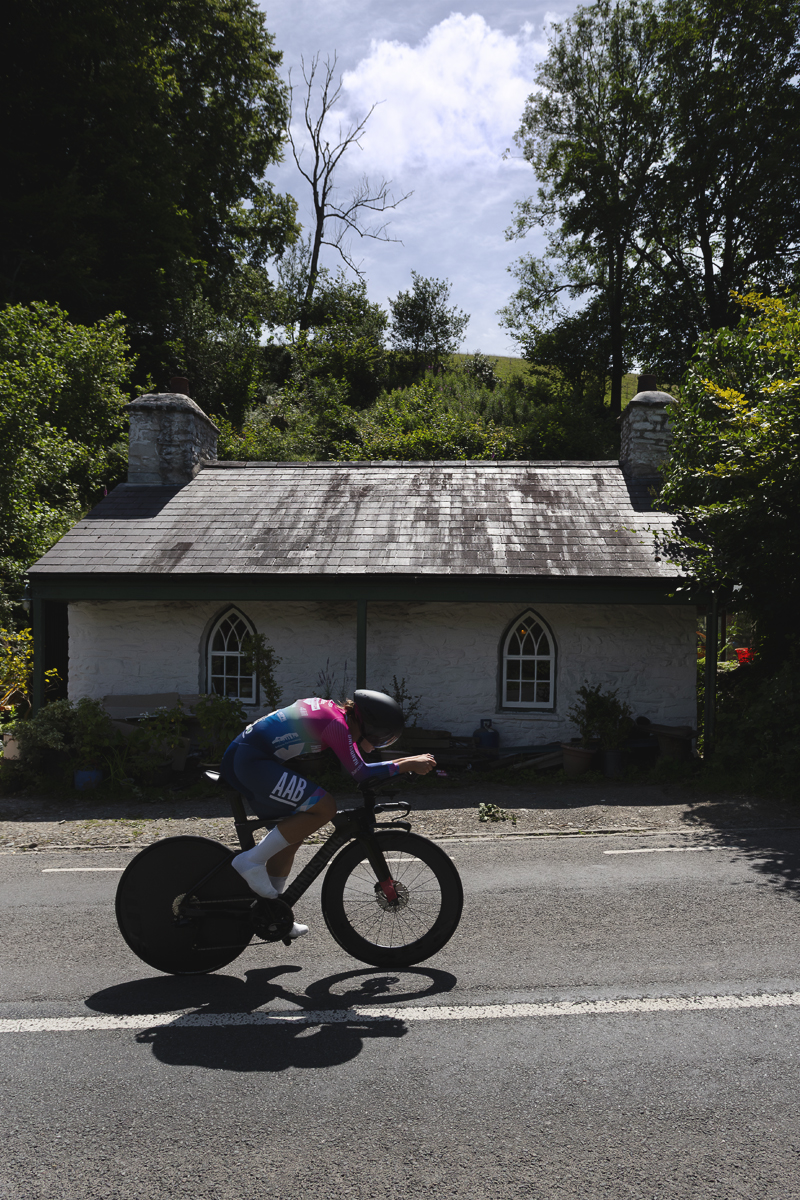 British National Road Championships 2025 - Time Trial - U23 Women - Mari Porton of Handsling Alba Development Road Team passes a small white cottage with arched windows