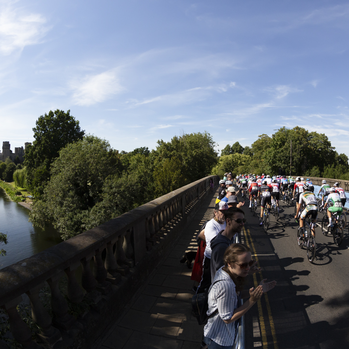Birmingham 2022 - XXII Commonwealth Games - Men’s Road Race - Riders cross the River Avon on Castle Bridge with Warwick Castle in background
