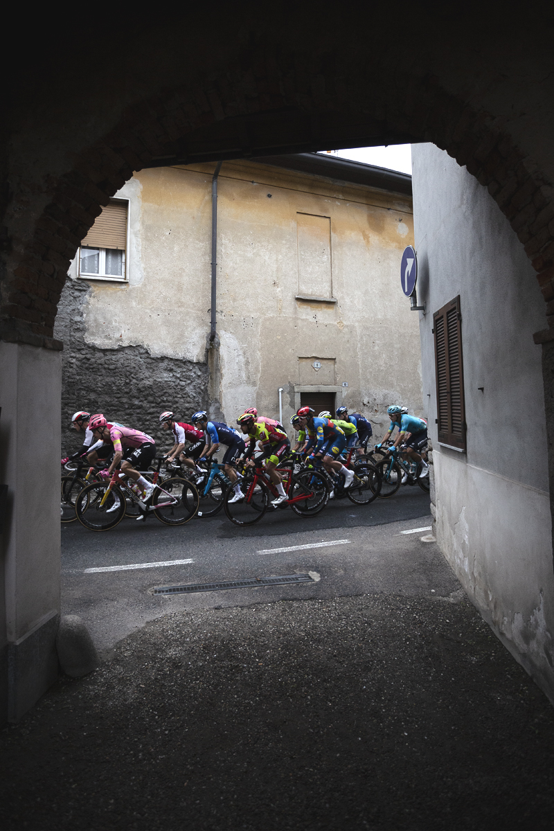 Coppa Bernocchi 2024 - The peloton seen through an archway in Castelseprio