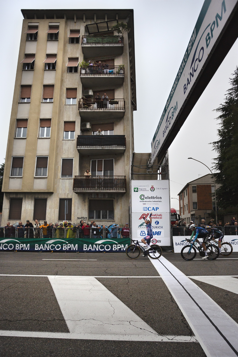 Coppa Bernocchi 2024 - A side view of Stan Van Tricht crossing the line victorious with a block of flats in the background
