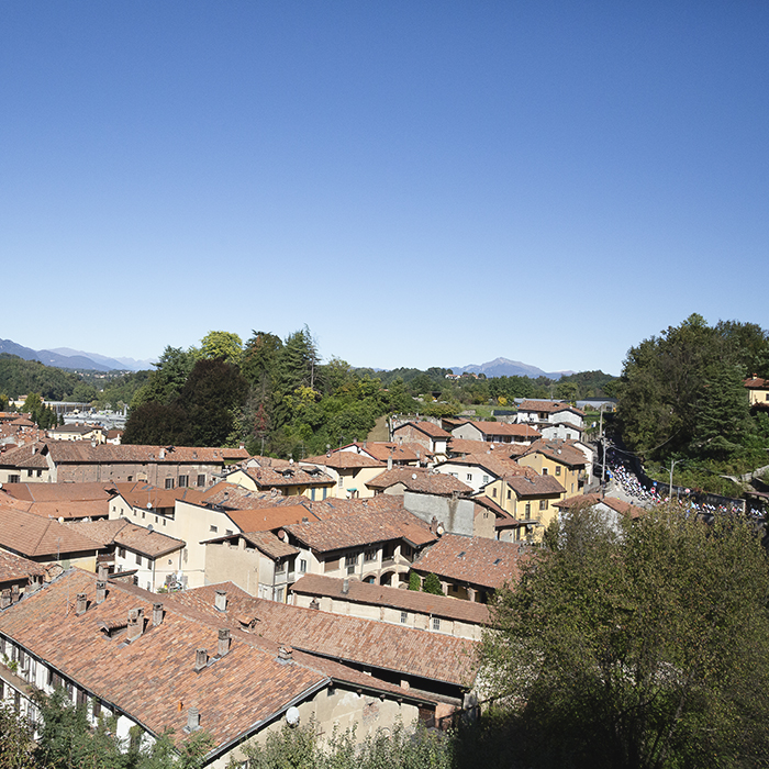 Coppa Bernocchi 2025 - The race can be seen rounding a bend in the distance with the rooftops of Castiglione Olona in the foreground
