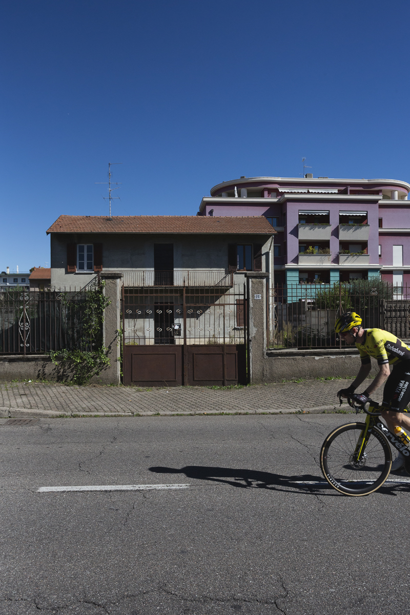 Coppa Bernocchi 2025 - Thomas Gloag rides in front of a set of old gates with more modern buildings visible in the background