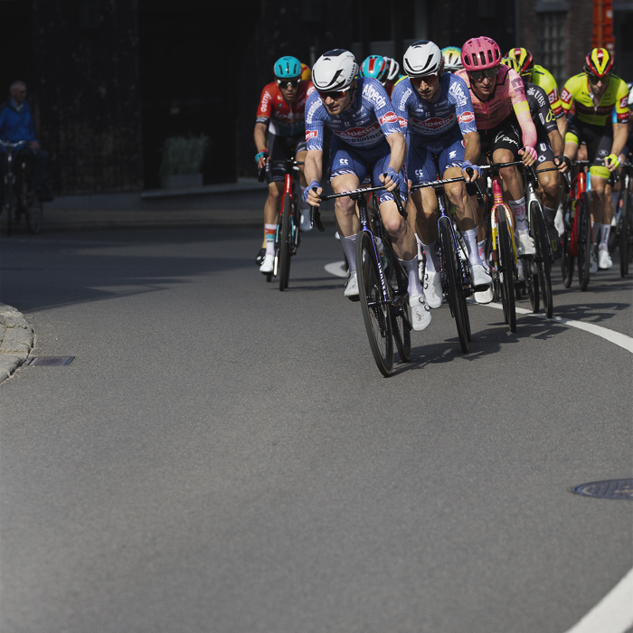 De Brabantse Pijl 2024 - Alpecin - Deceuninck lead riders round the curve of a bend in Overisje
