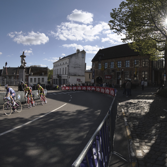 De Brabantse Pijl 2024 - Sun shines through a tree on Justus Lipsiusplein as the riders pass by
