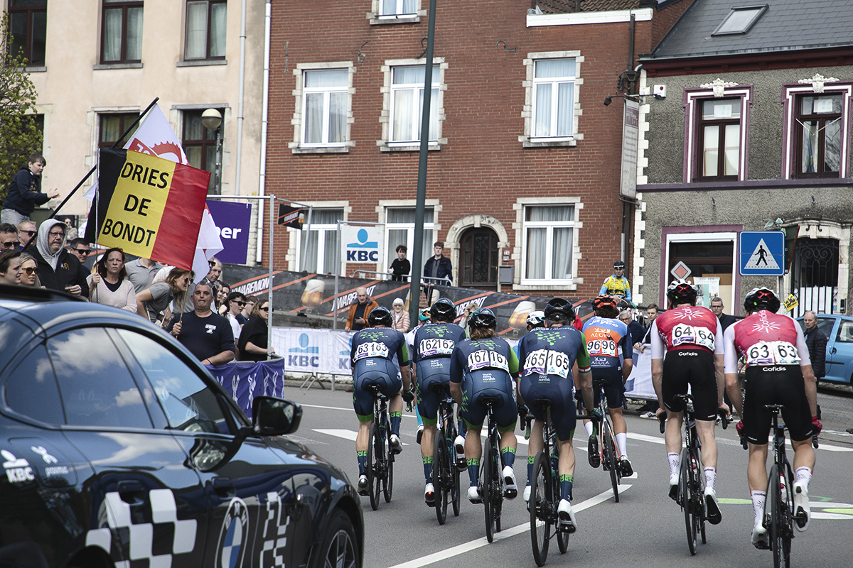 De Brabantse Pijl 2024 - The riders of Team Novo Nordisk pass a group of fans holding a  Belgian tricolour with Dries de Bondt written on it
