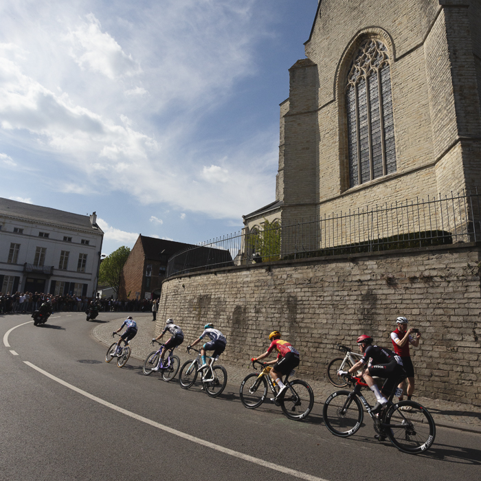 De Brabantse Pijl 2025 - A group of riders pass the church as they begin to take on the climb in Overijse