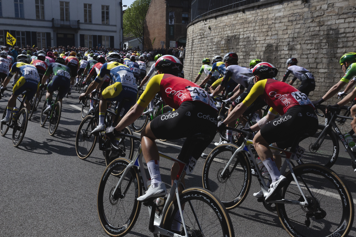 De Brabantse Pijl 2025 - Riders seen from behind as they race through the streets of Overijse