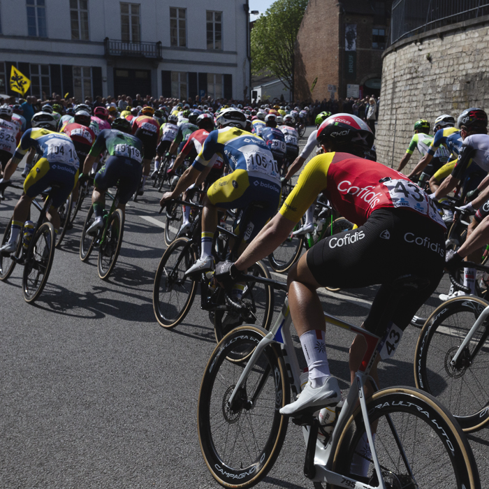De Brabantse Pijl 2025 - Riders seen from behind as they race through the streets of Overijse