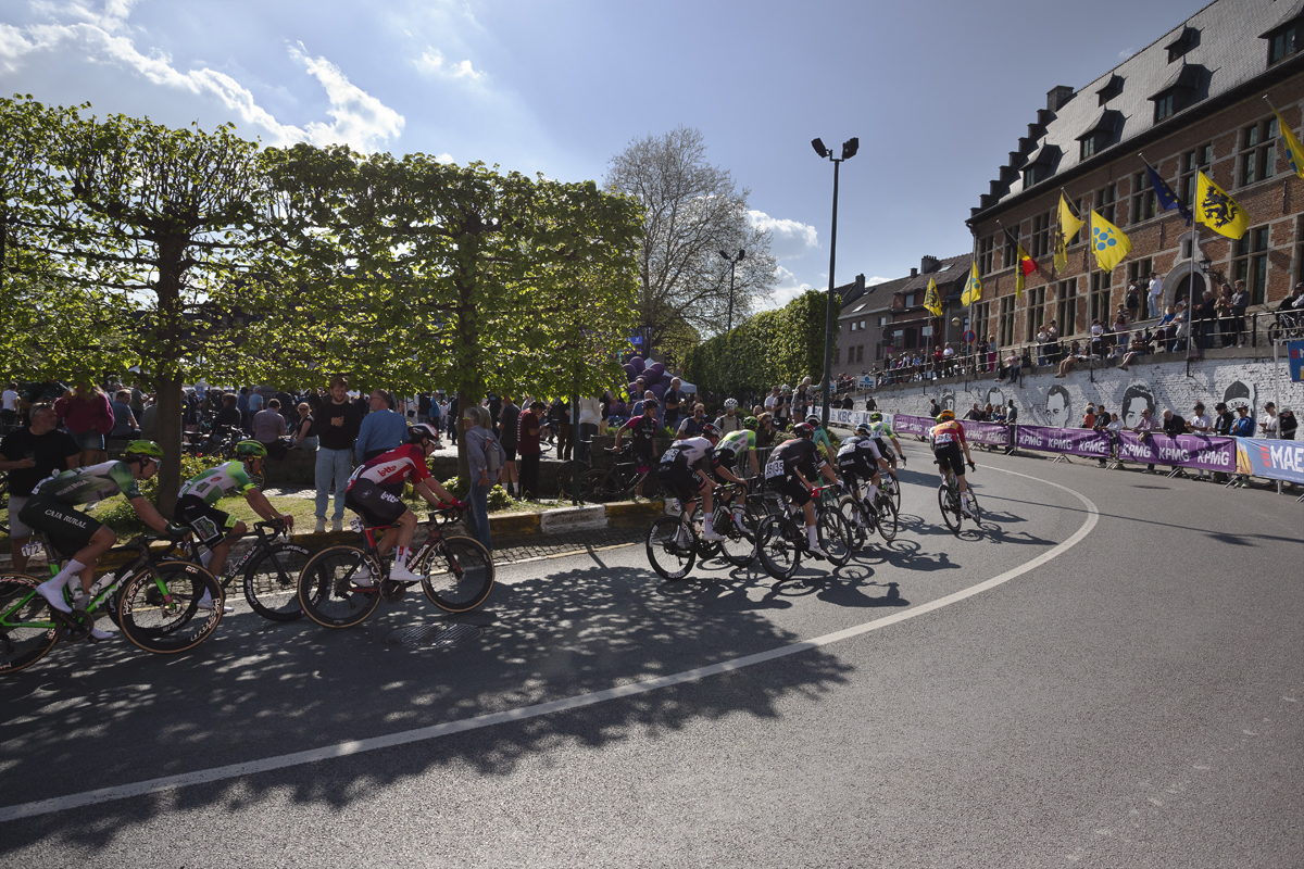 De Brabantse Pijl 2025 - Riders on the S-Bocht with the Town Hall flying flags of Flanders in the background