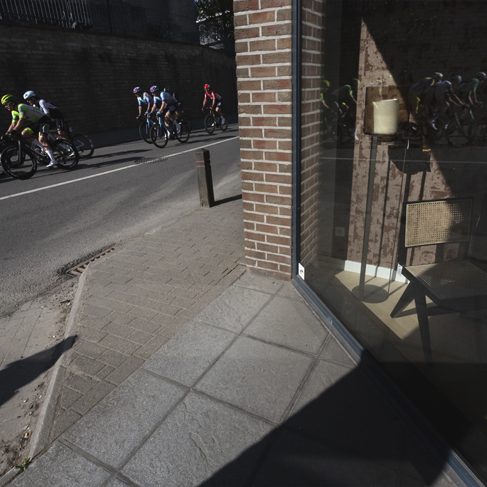 De Brabantse Pijl 2025 - The race is reflected in a shop window in Overijse