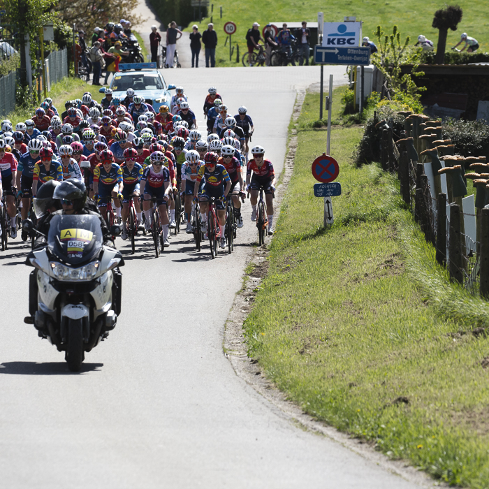 De Brabantse Pijl Vrouwen 2024 - The peloton move up Holstheide past a fence adorned with upside down wellington boots - a symbol of a farmer’s protest