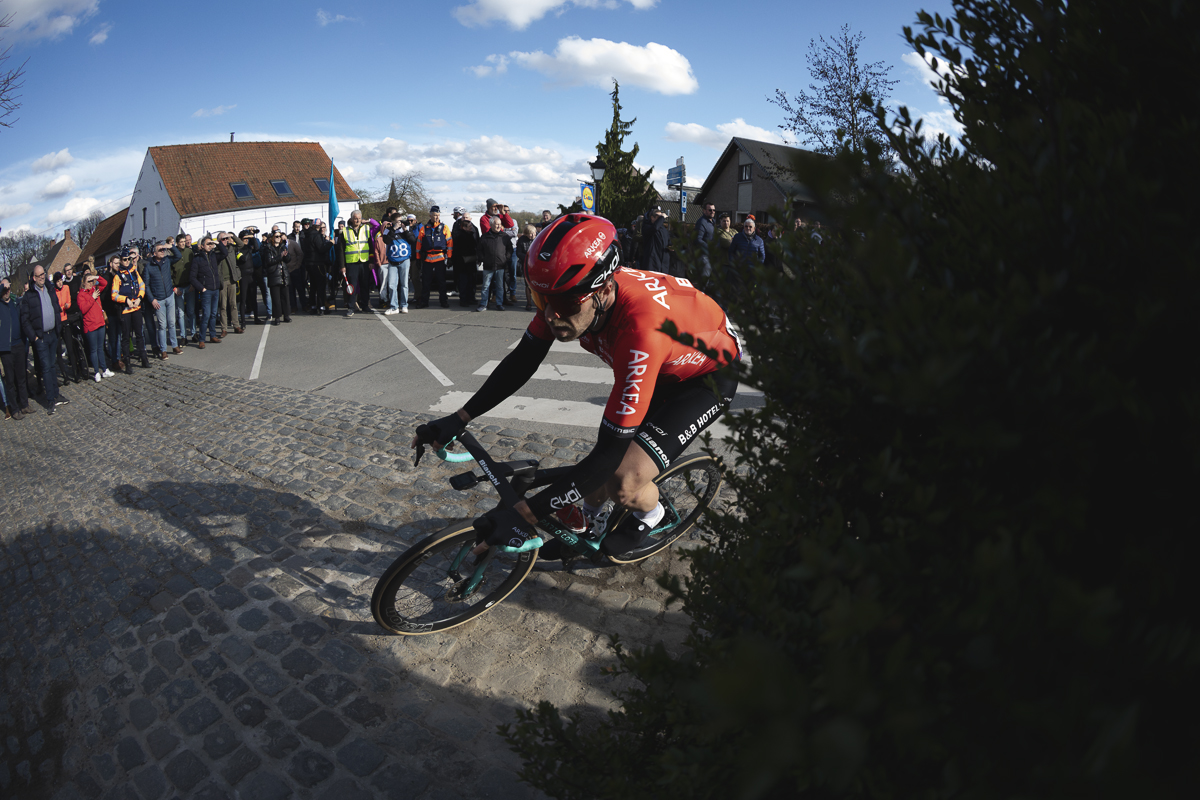 Dwars Door Vlaanderen 2024 - Dan McLay rounds a corner watched by fans lining the road