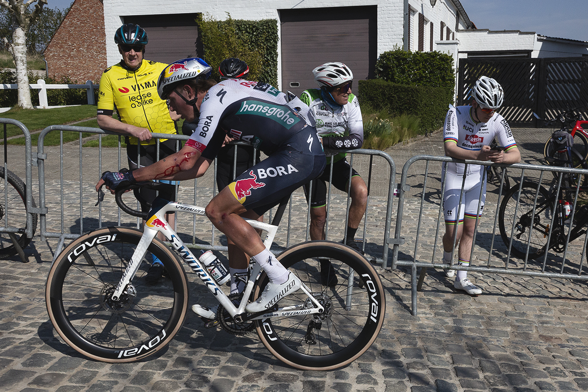 Dwars Door Vlaanderen 2025 - Laurence Pithie is watched by a group of seemingly unimpressed fans on the Eikenberg