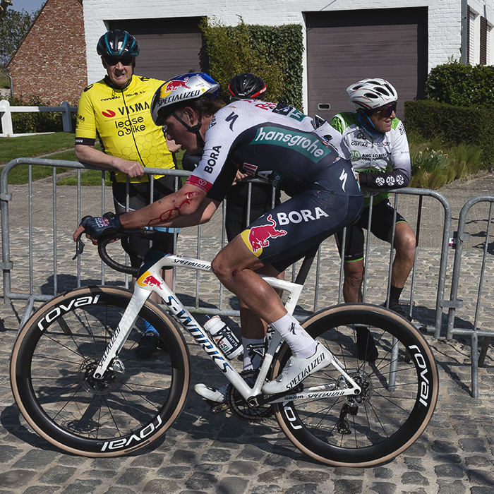 Dwars Door Vlaanderen 2025 - Laurence Pithie is watched by a group of seemingly unimpressed fans on the Eikenberg