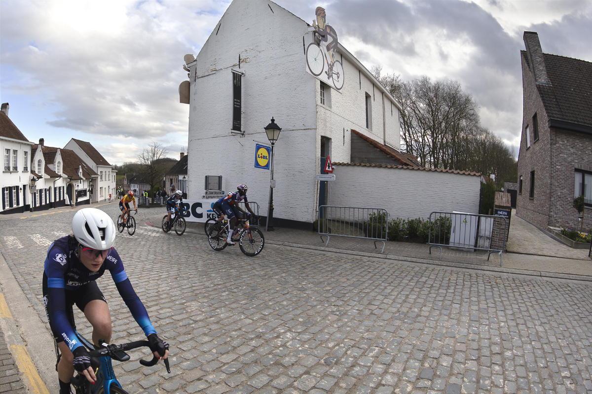 Dwars Door Vlaanderen Vrouwen 2024 - Cleo Kiekens tackles the Nokereberg climb the white washed buildings of Nokere as a backdrop
