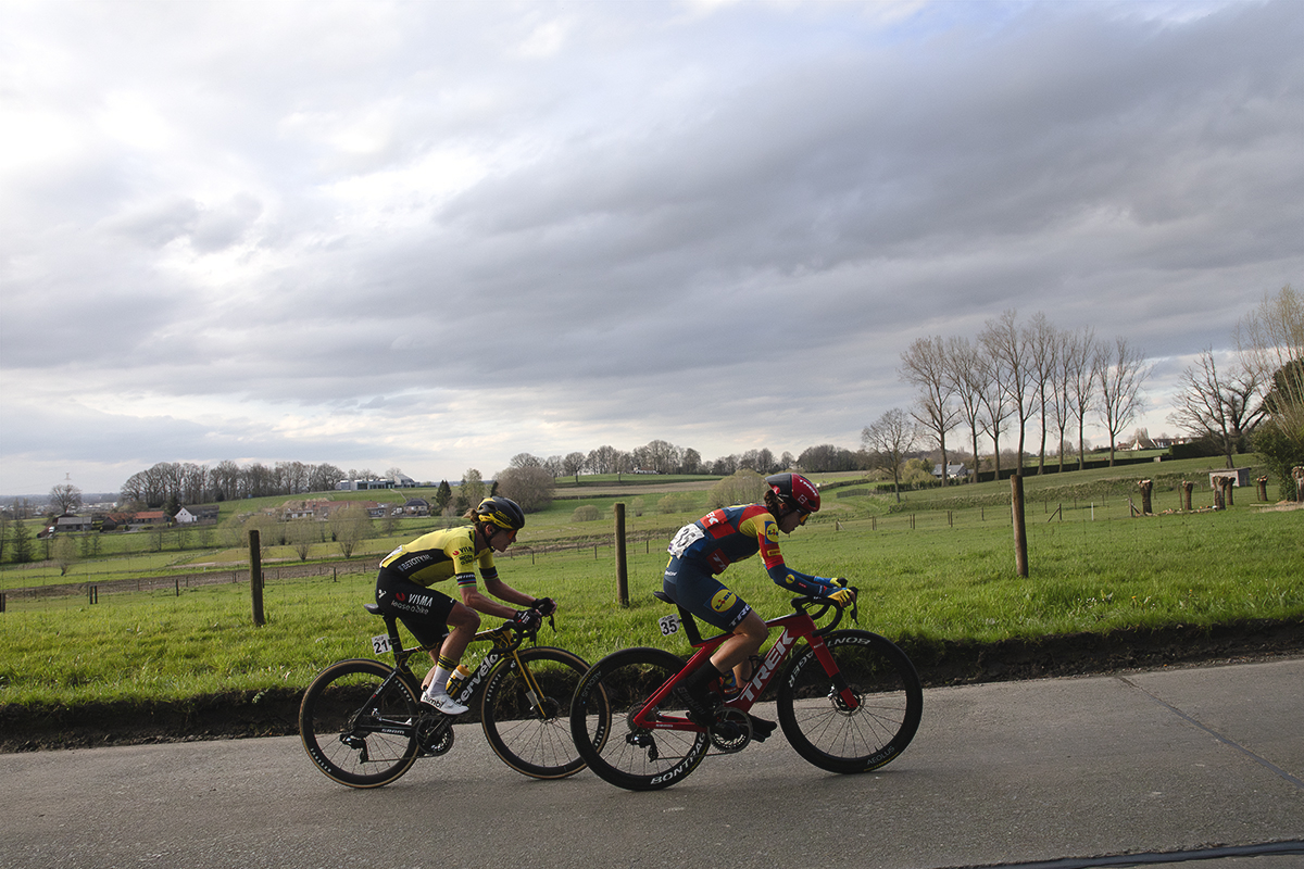 Dwars Door Vlaanderen Vrouwen 2024 - Marianne Vos and Shirin van Anrooij with open fields behind them as they race up a small climb