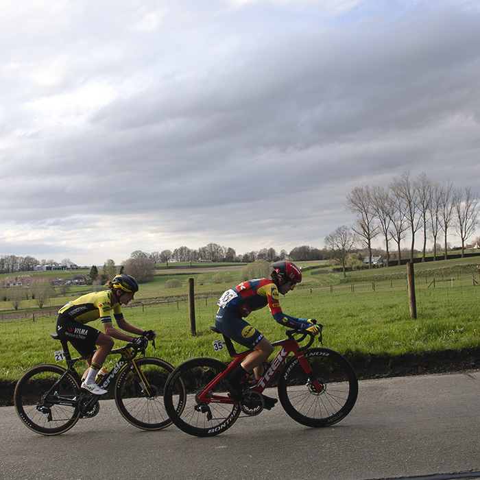 Dwars Door Vlaanderen Vrouwen 2024 - Marianne Vos and Shirin van Anrooij with open fields behind them as they race up a small climb