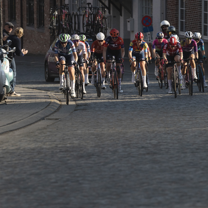Dwars Door Vlaanderen Vrouwen 2025 - A group of riders on the cobbles in the village of Nokere