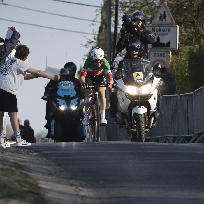 Dwars Door Vlaanderen Vrouwen 2025 - Elisa Longo Borghini is closely followed by a TV Moto as fans hold signs of support