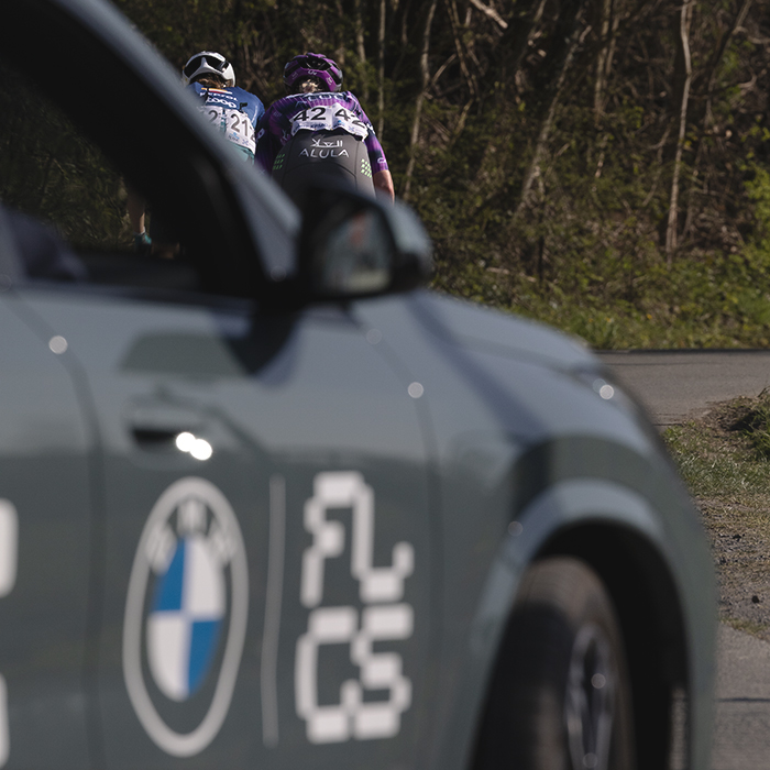 Dwars Door Vlaanderen  Vrouwen 2025 - Stina Kagevi and Amber Pate seen from behind framed by a race vehicle