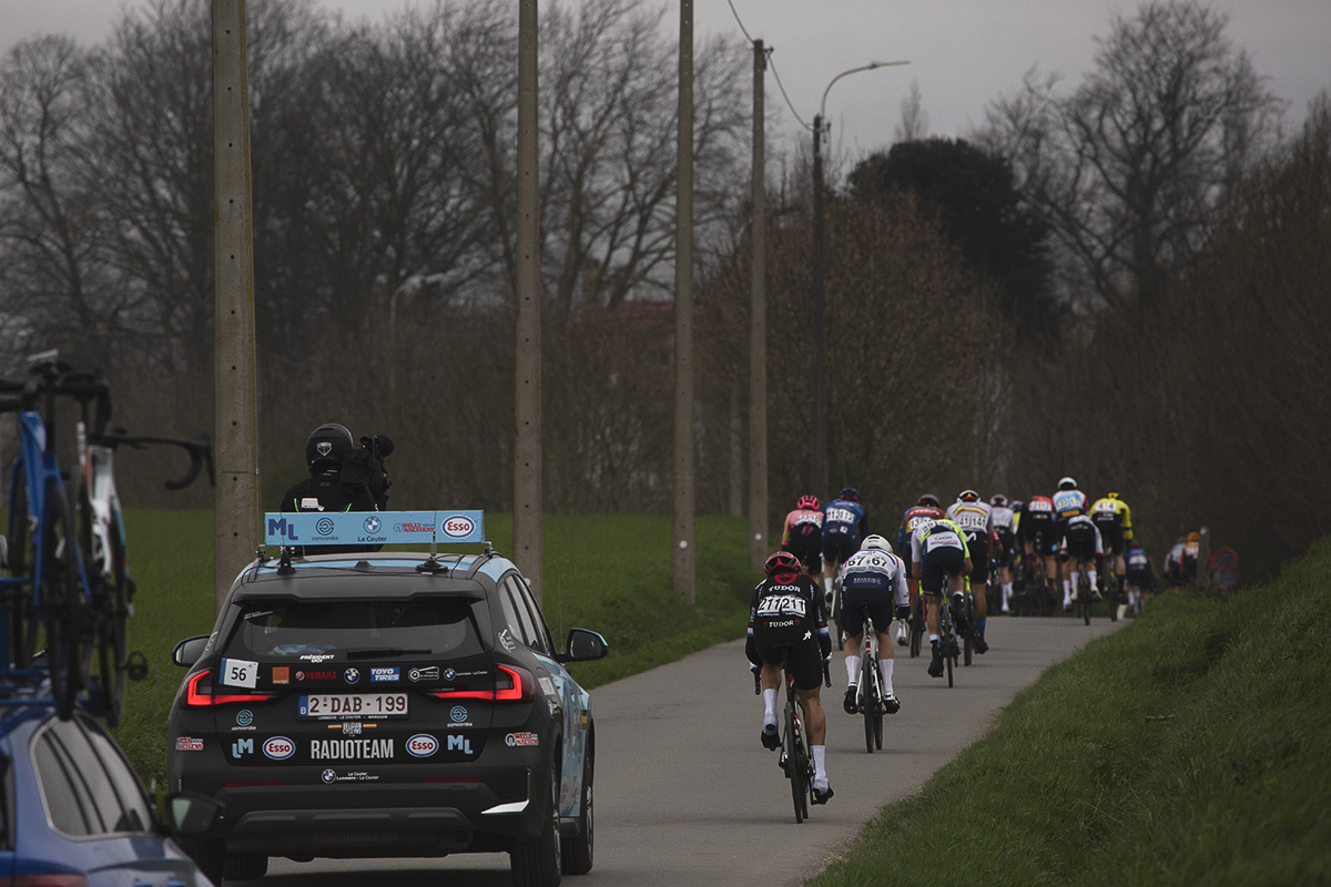 E3 Saxo Classic 2024 - A group of riders are followed by a race vehicle