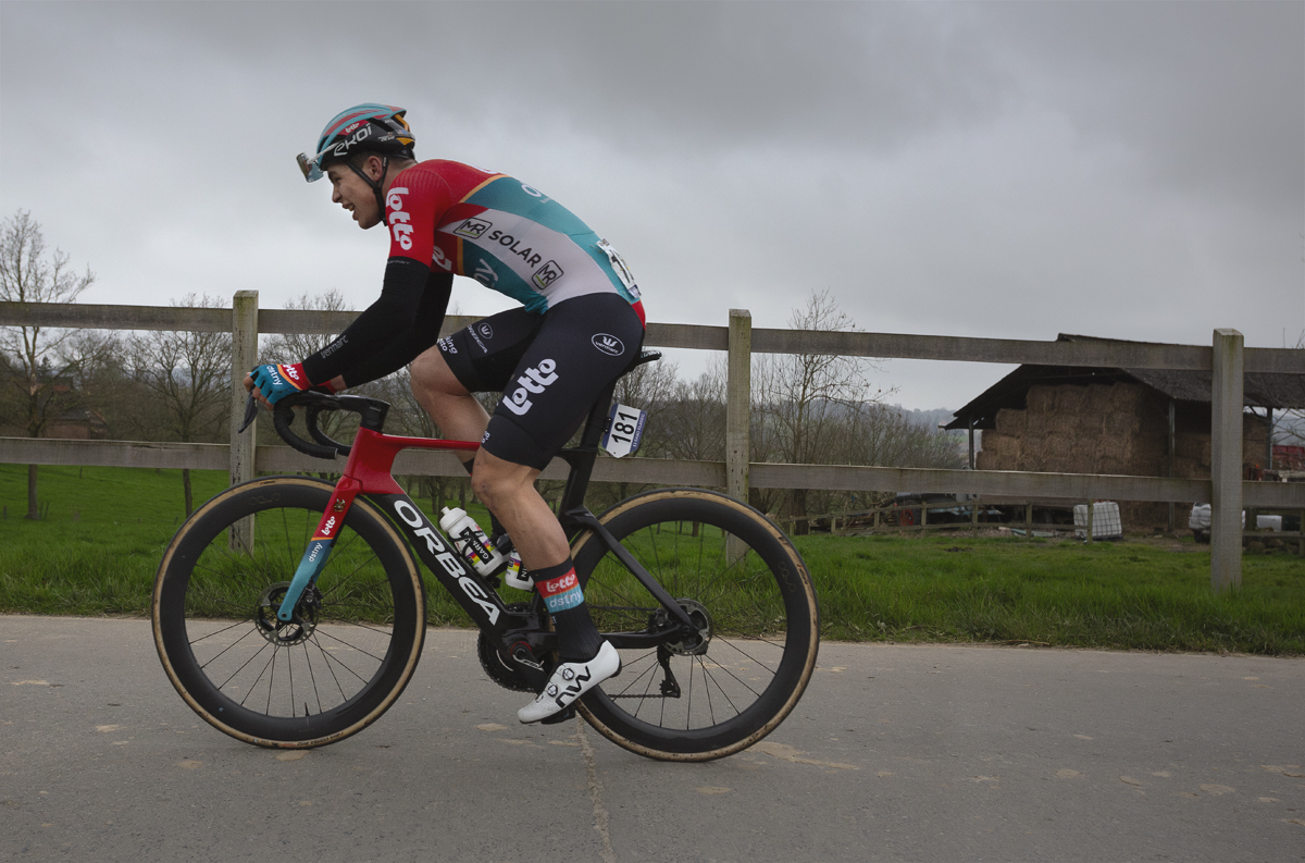 E3 Saxo Classic 2024 - Arnaud De Lie passes in front of a field and farm buildings