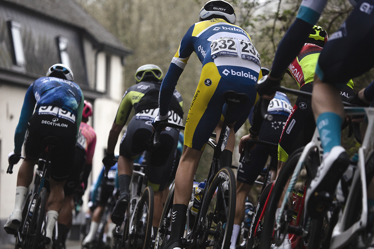 E3 Saxo Classic 2024 - The peloton moves off down rijkswachtdreef