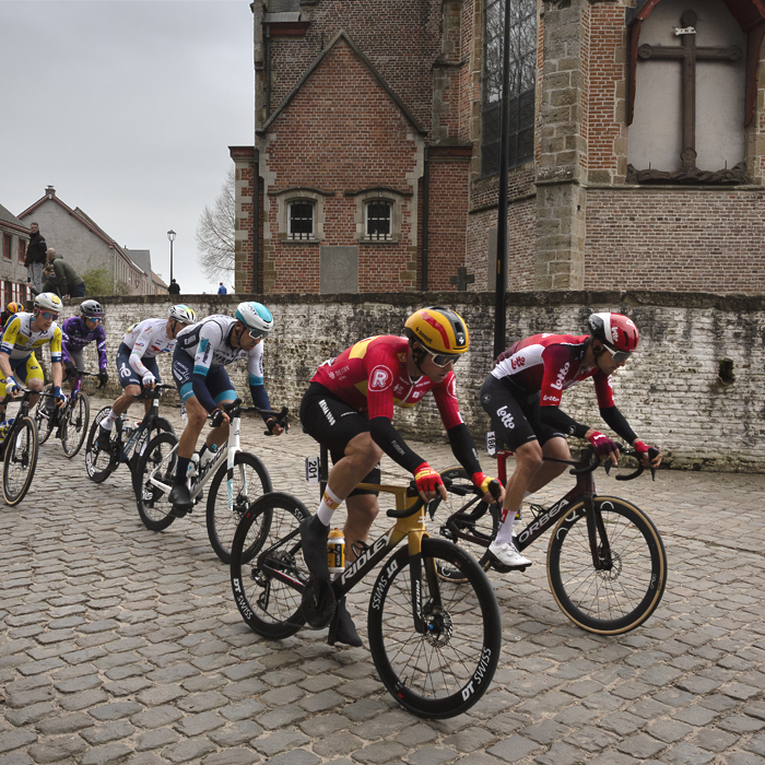 E3 Saxo Classic 2025 - Riders on the cobbles pass Sint Denijskerk
