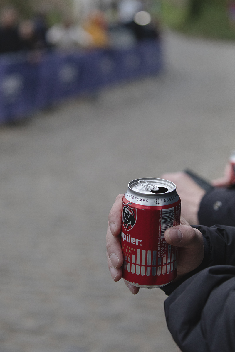 E3 Saxo Classic 2025 - A fan holds a can of Belgian beer as they wait for the race