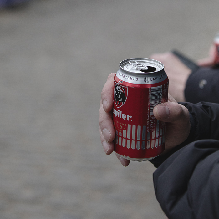 E3 Saxo Classic 2025 - A fan holds a can of Belgian beer as they wait for the race