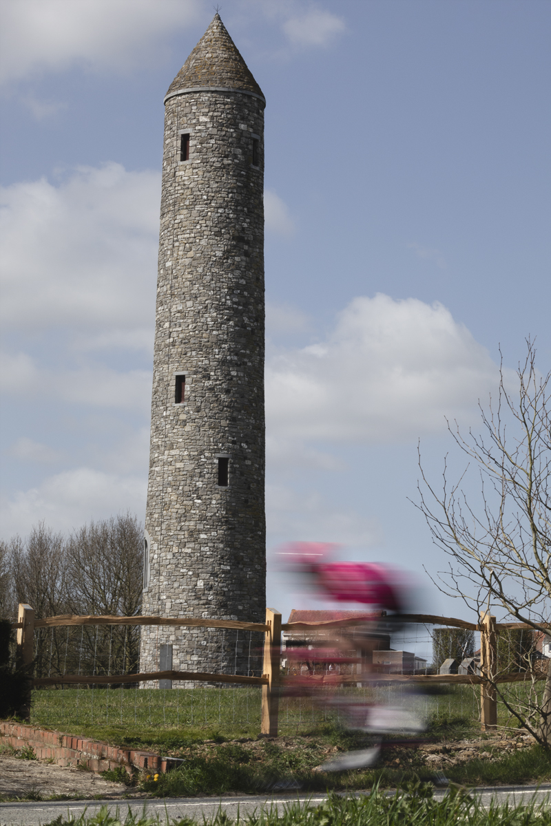 Gent Wevelgem 2025 - A rider speeds past the Irish Peace Tower
