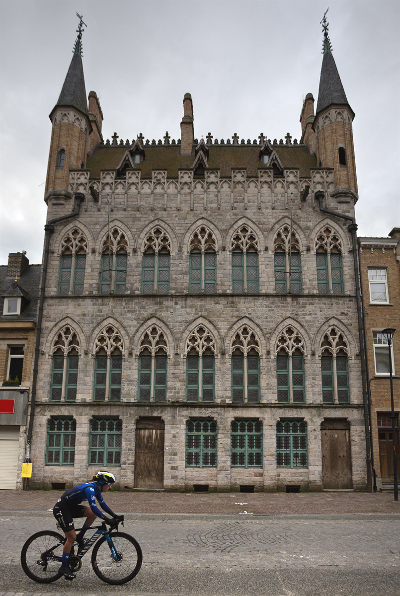 Gent Wevelgem Vrouwen 2024 - Laura Ruiz Pérez rides in front of the grand facade of a Flemish building