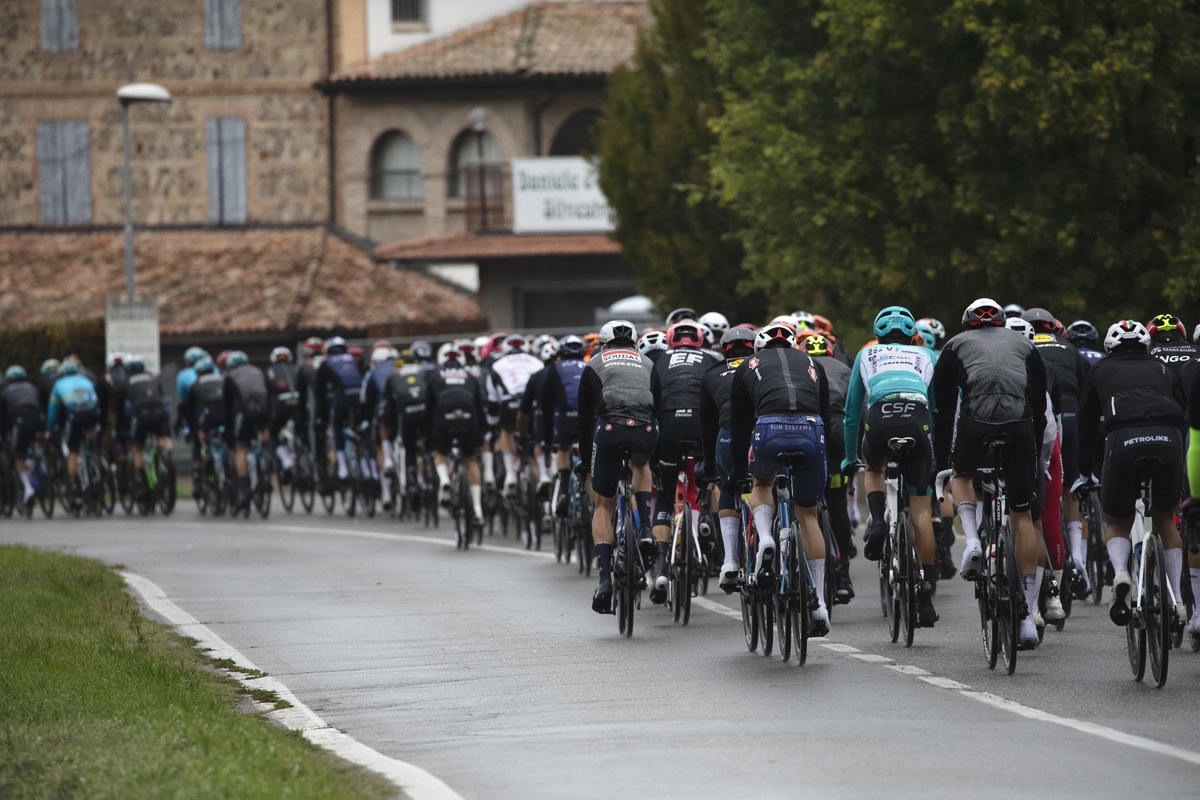 Giro dell’Emilia 2024 - The peloton from the rear clad in rain jackets in Castelvetro